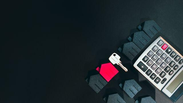 A house key, calculator, and small house figurines